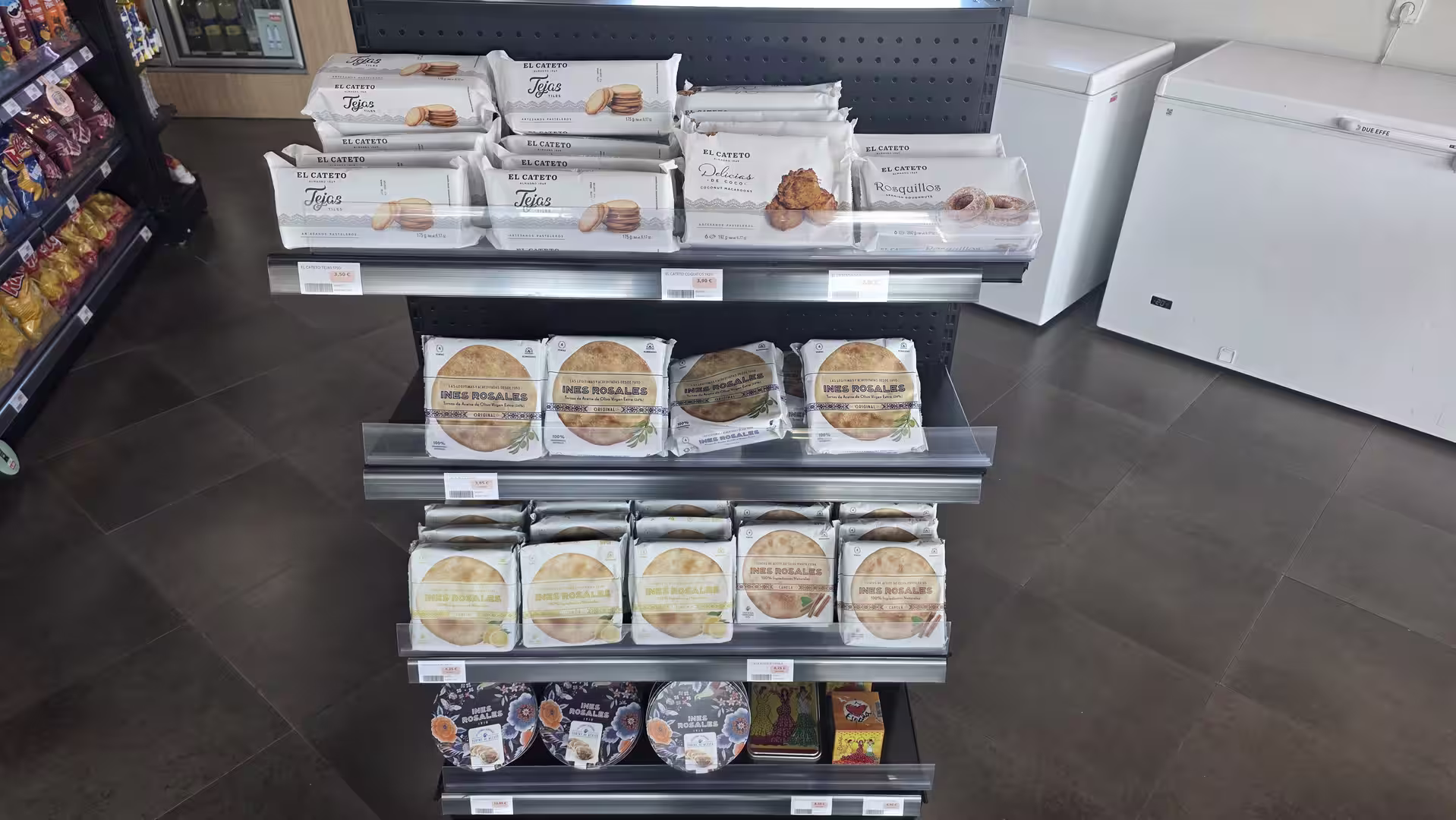 Display shelf with packaged Spanish pastries, biscuits, and traditional baked goods in a convenience store.