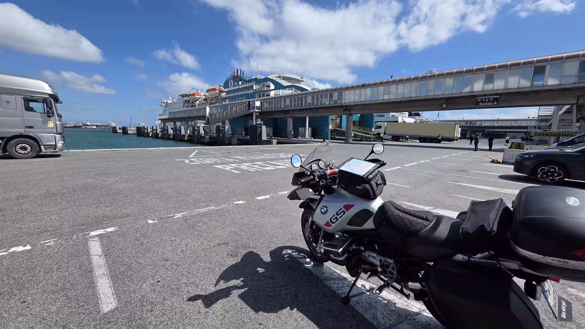 Adventure motorcycle parked beside a ferry terminal in Algeciras, Spain.