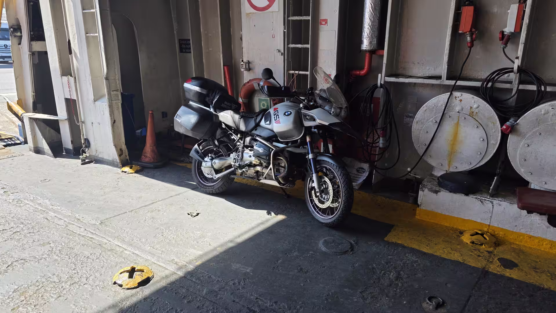 Touring motorcycle parked inside a ferry during a Mediterranean crossing.