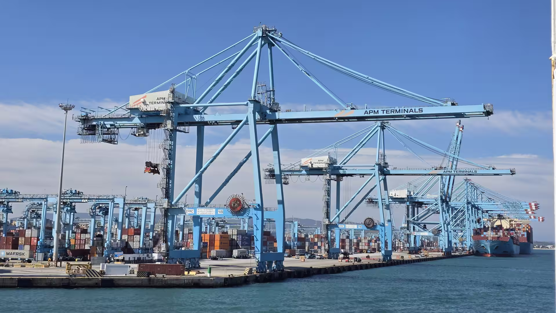 Container cranes and stacked shipping containers at the Port of Algeciras.