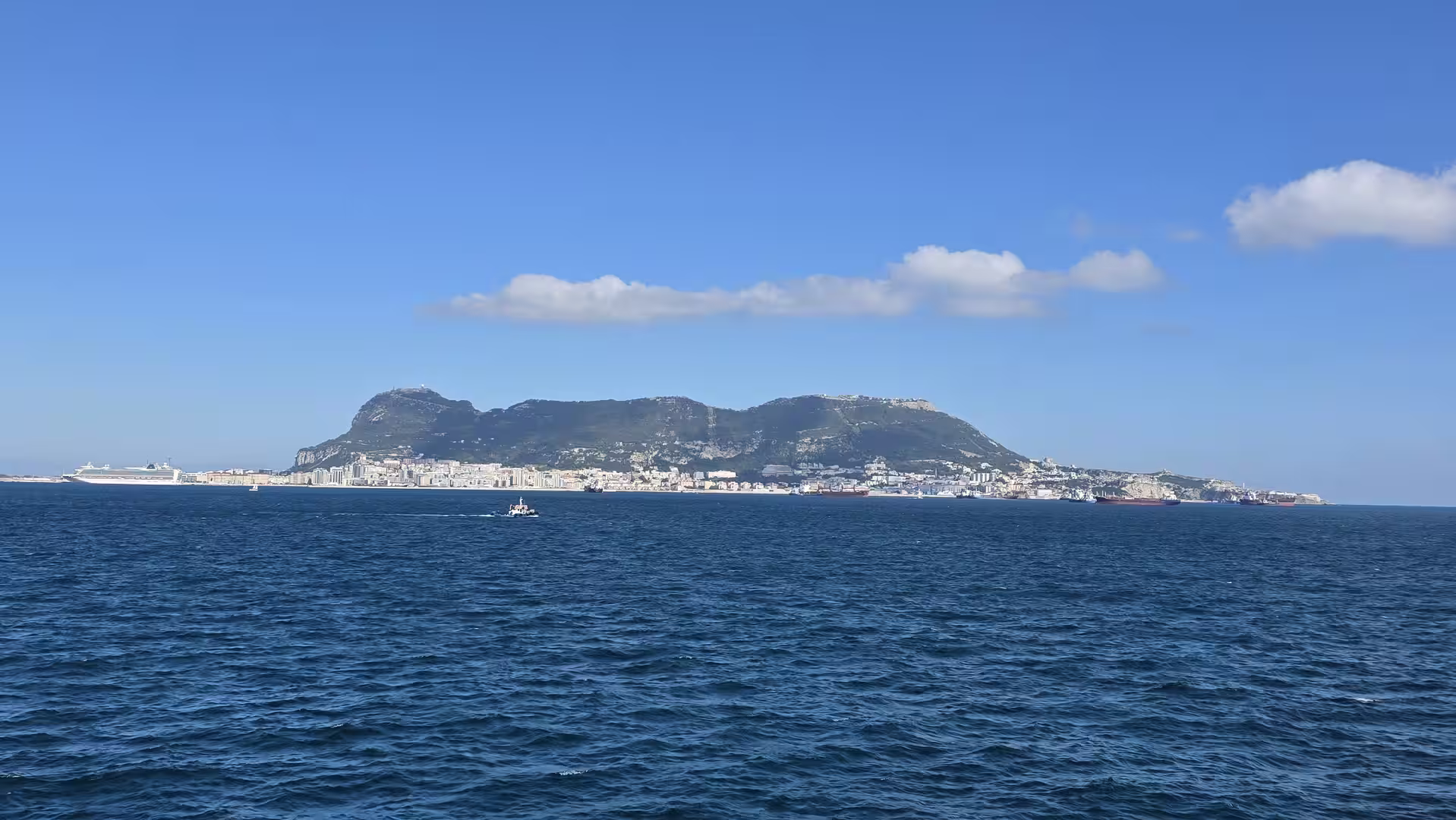 View of the Rock of Gibraltar rising above the coastline across the Strait of Gibraltar.