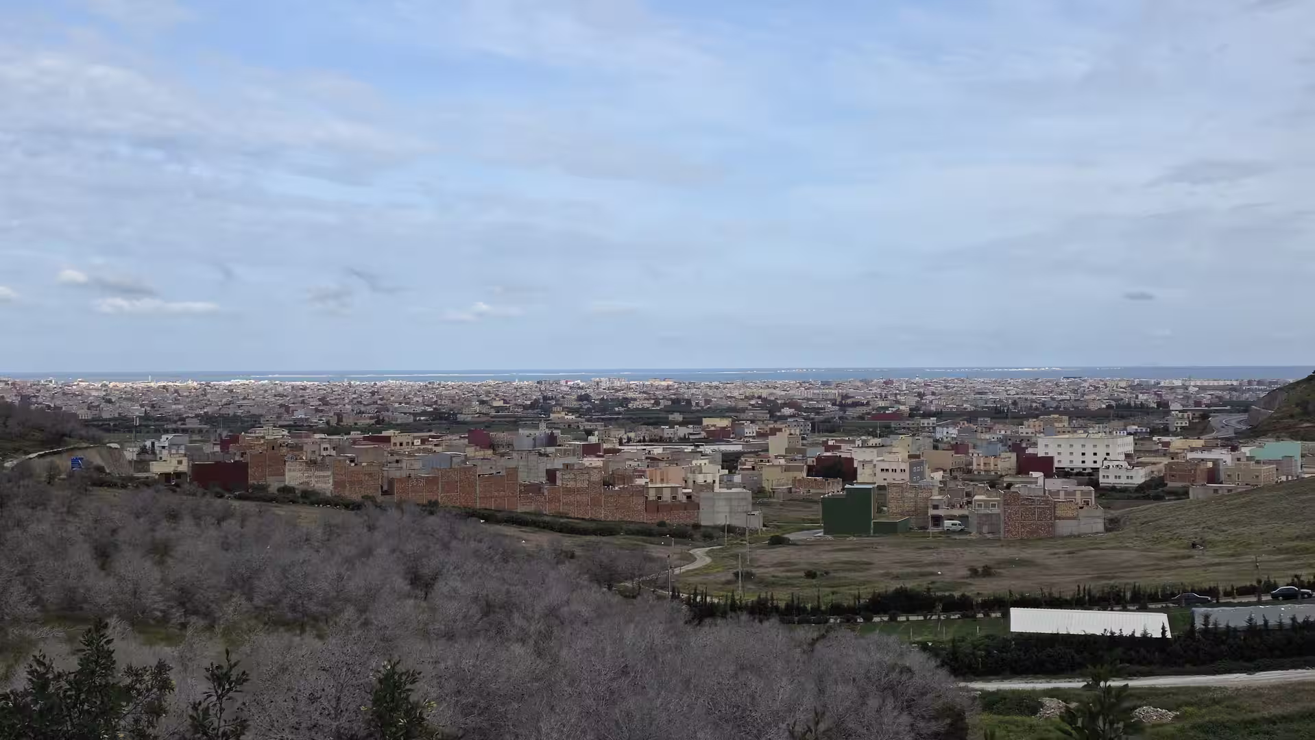 Panoramic view over Nador with urban districts stretching toward the Mediterranean Sea.
