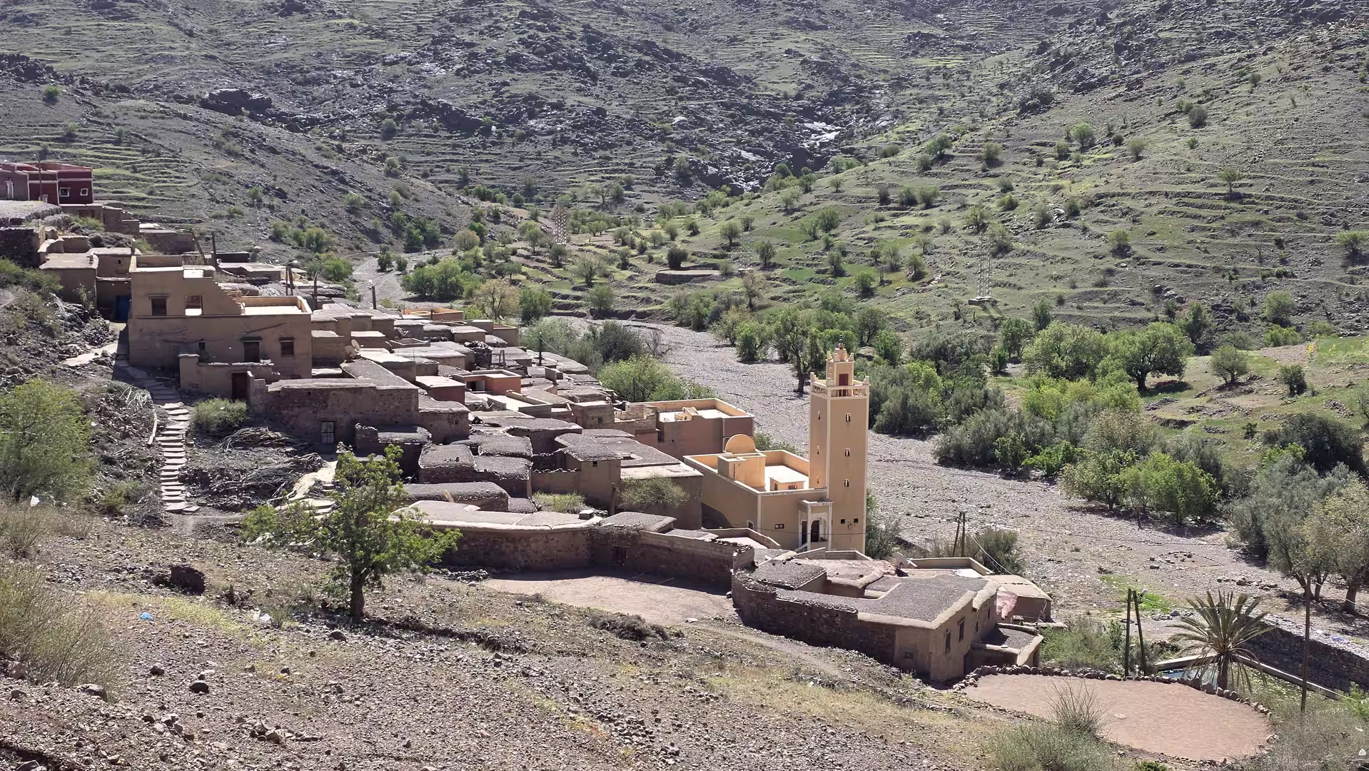 Traditional mountain village with a mosque beside a dry valley in the Anti-Atlas.