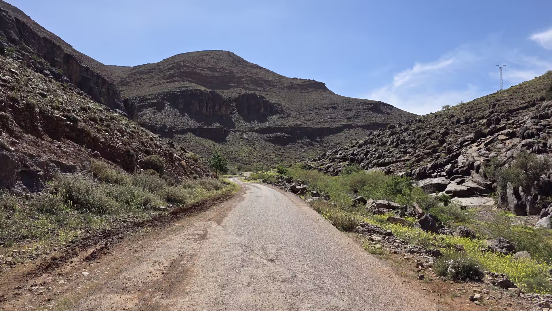 Narrow mountain road running through a rocky valley in the Anti-Atlas.