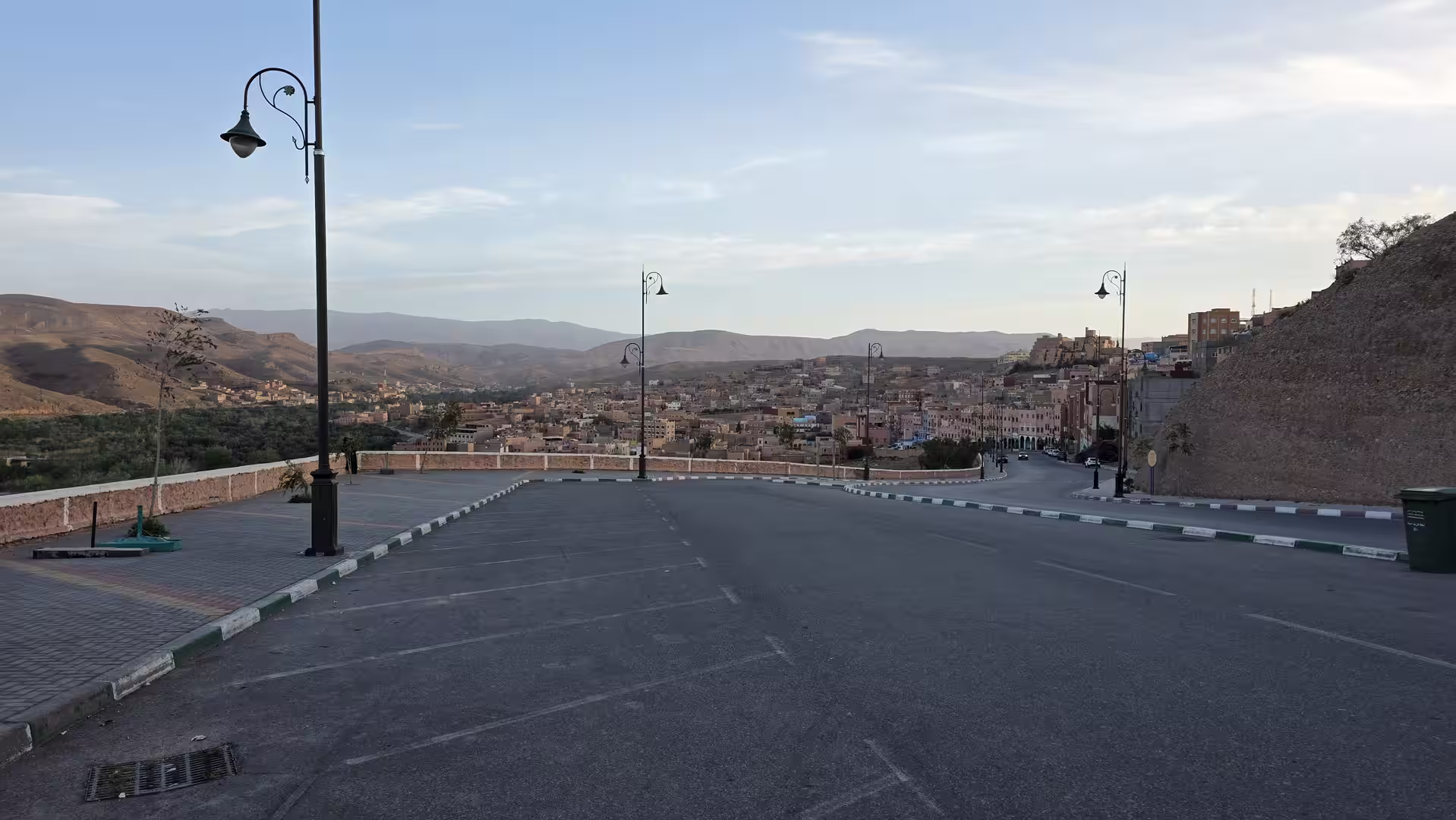 Wide street overlooking Boumalne and its green valley in the early morning light of southern Morocco.