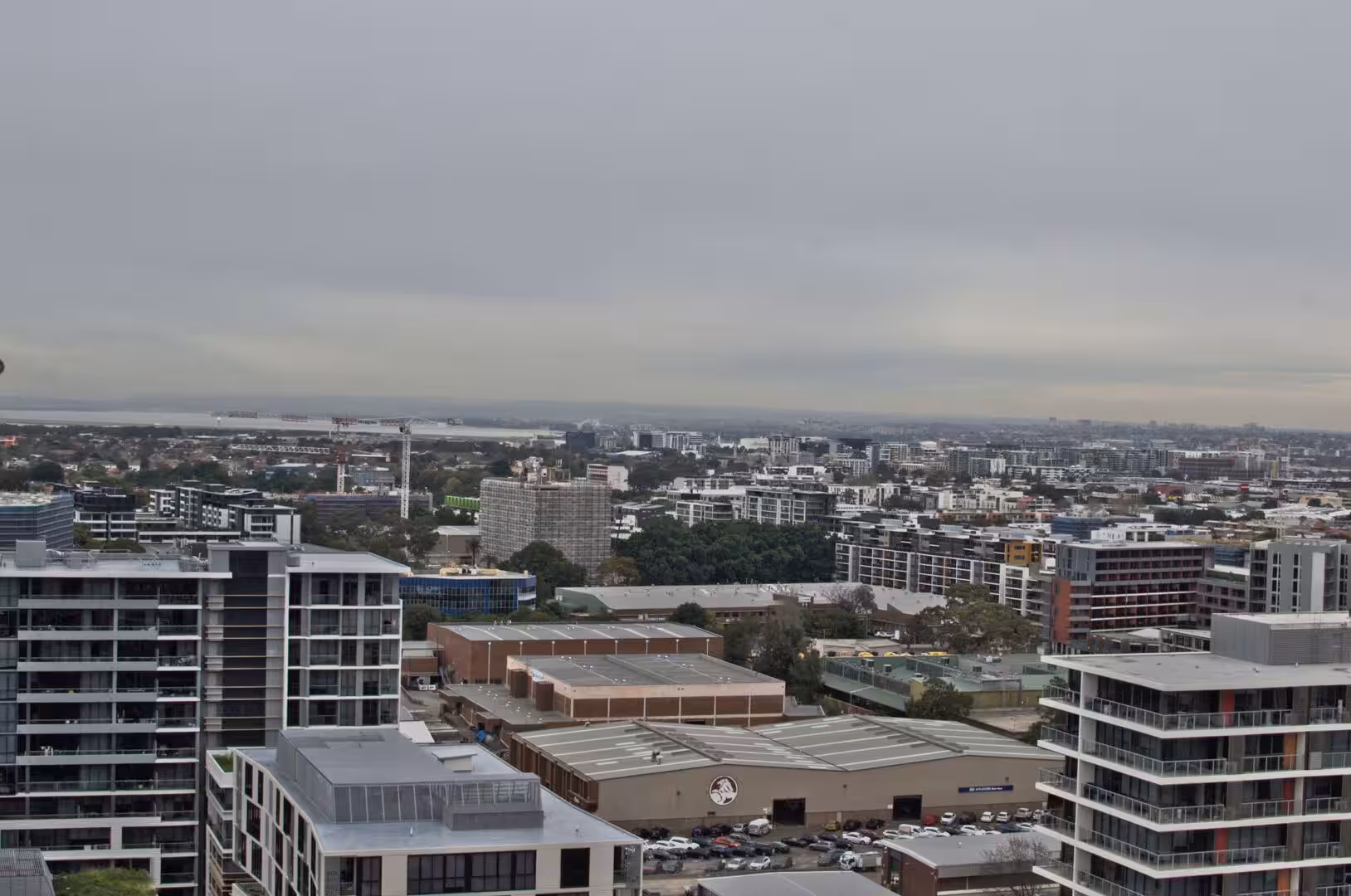 Modern apartment towers and streets stretch below under a gray sky.
