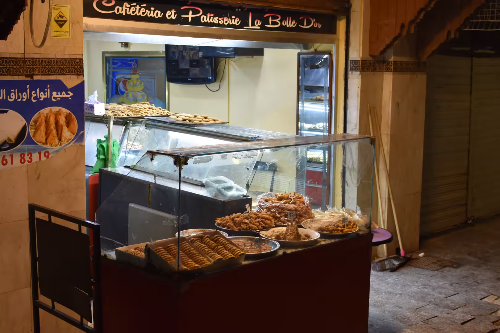 Display of traditional Moroccan pastries in a small bakery in Oujda.