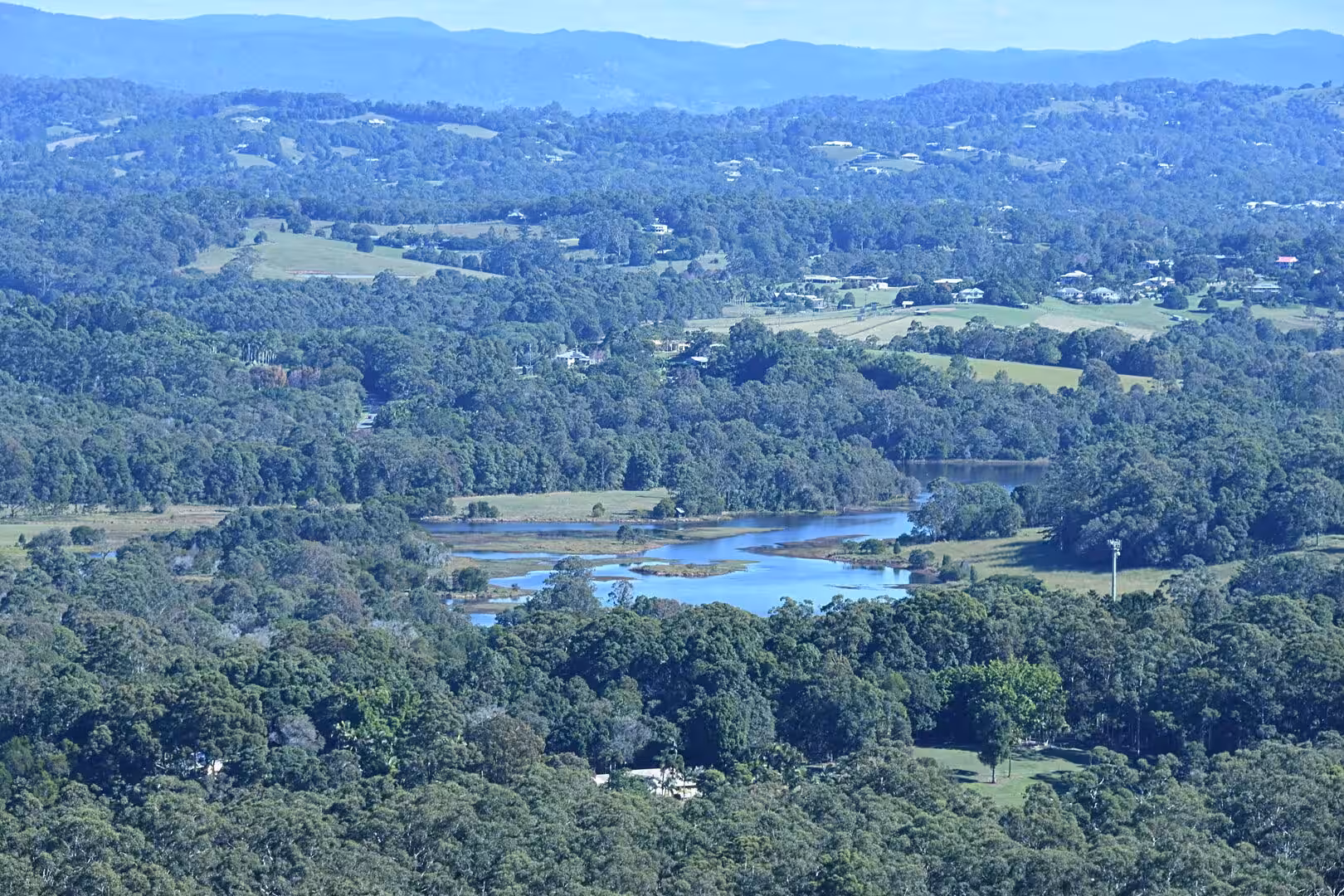 A curving blue lake threads through dense forest and patchwork farmland.