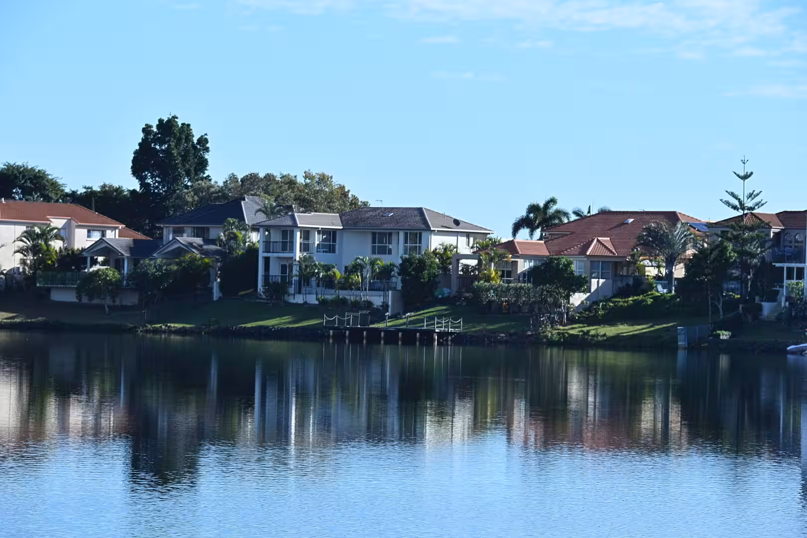 A row of houses along a tranquil canal reflects in the water.