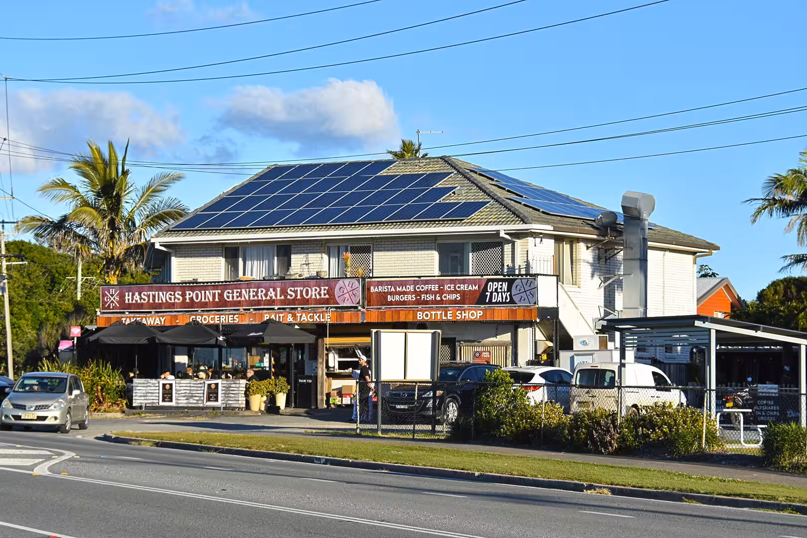The Hastings Point General Store fronts a busy road with coffee, takeaway and bottle shop signs.