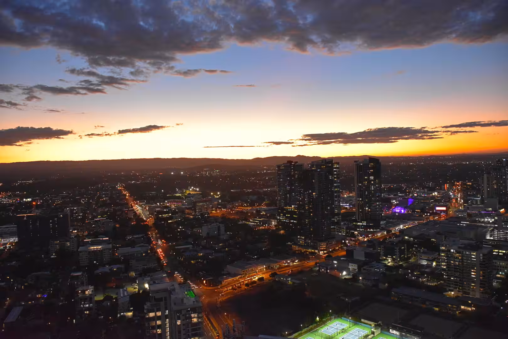 City towers and lit streets come alive as dusk deepens into night.
