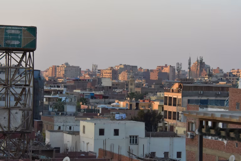 Sprawling city rooftops under a hazy sky.