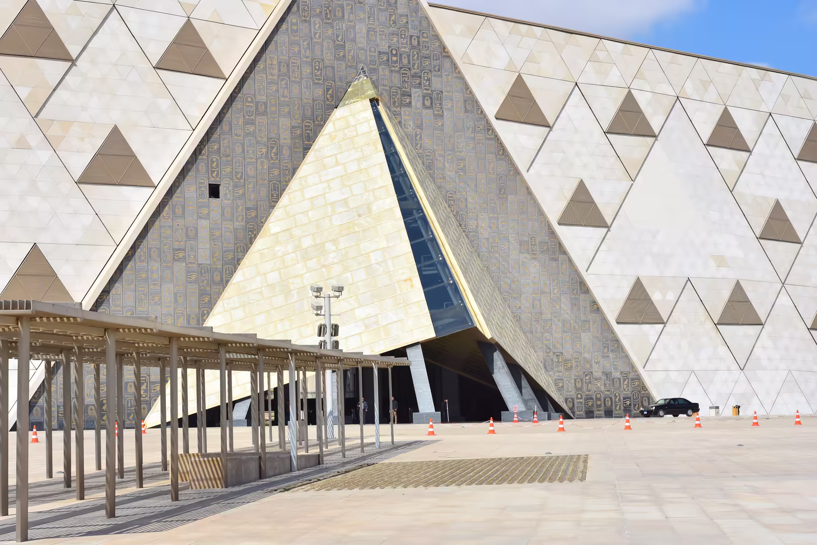 A modern museum's sloping facade rises in triangular stone and glass.